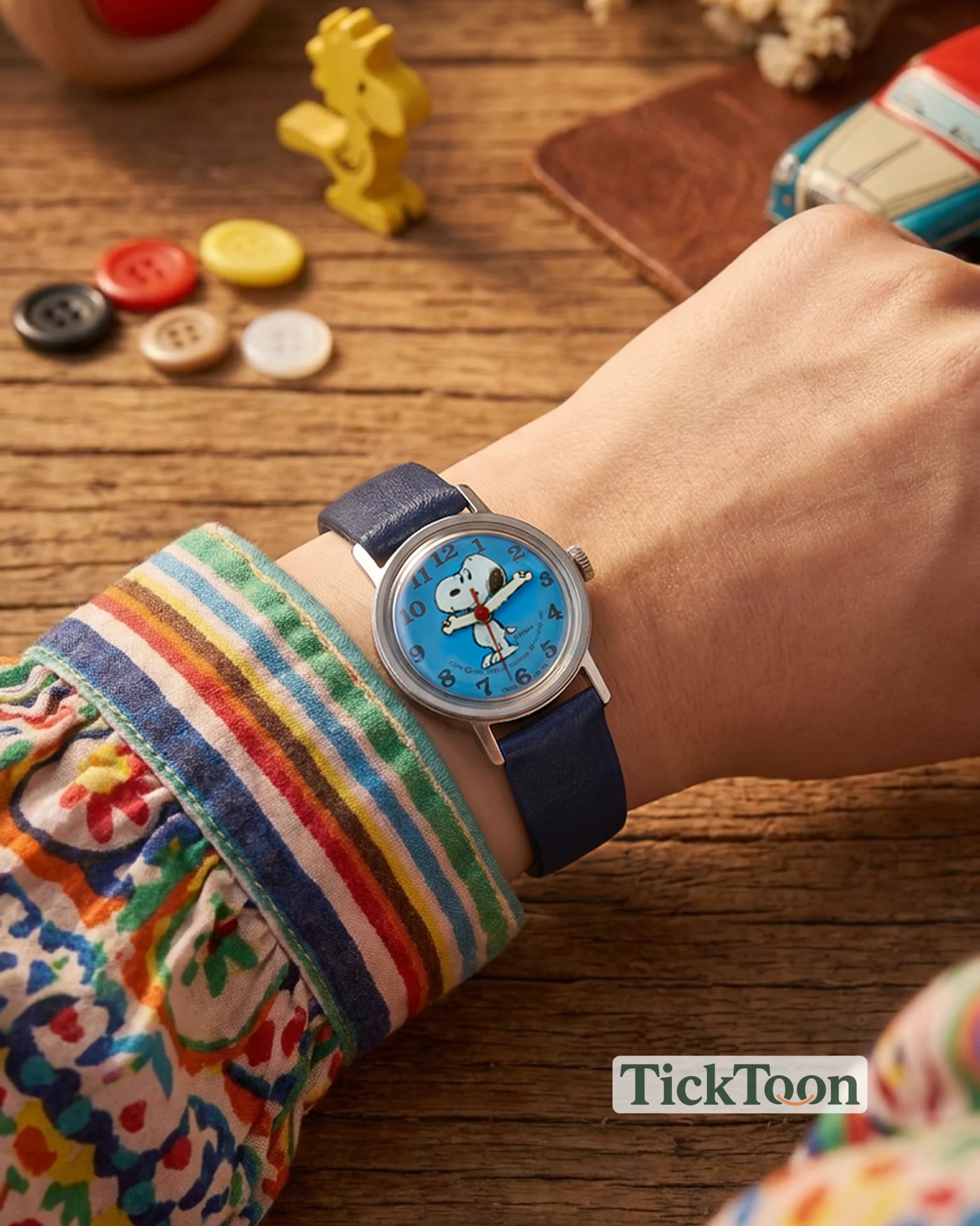 A blue Snoopy watch styled on a wrist from the TickToon collection.